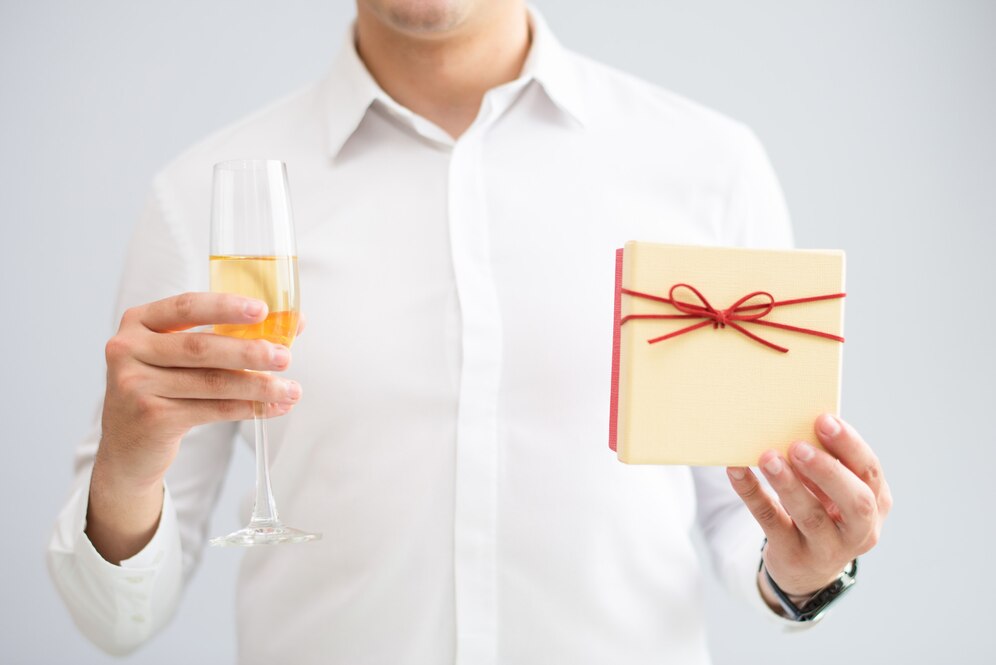 closeup-man-holding-glass-with-champagne-gift-box_1262-16937.jpg