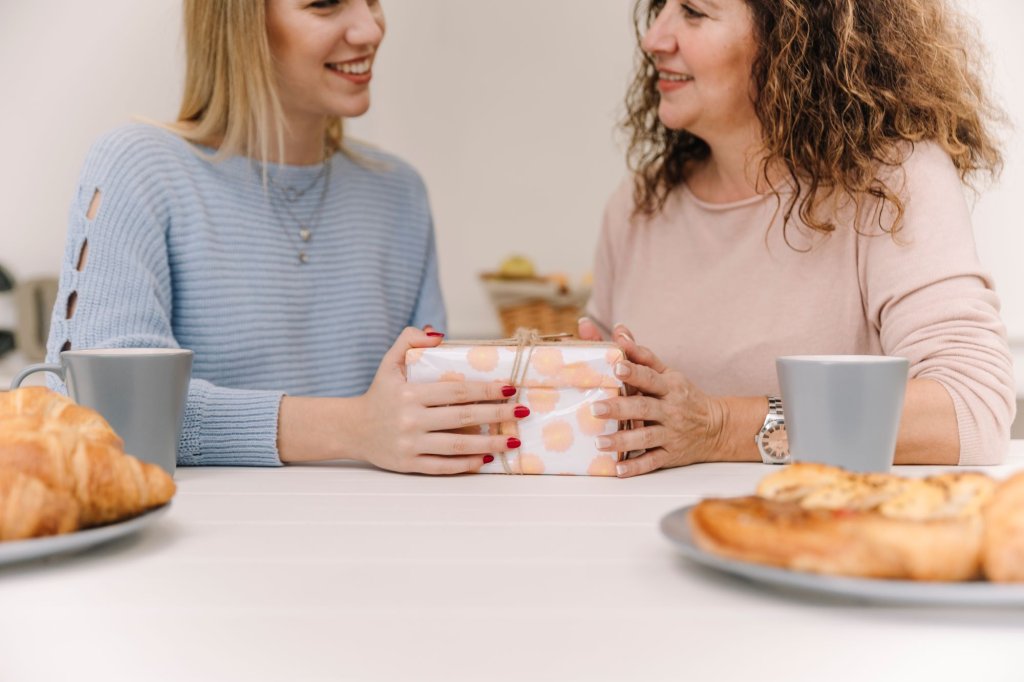 smiling-woman-giving-gift-mom-breakfast.jpg